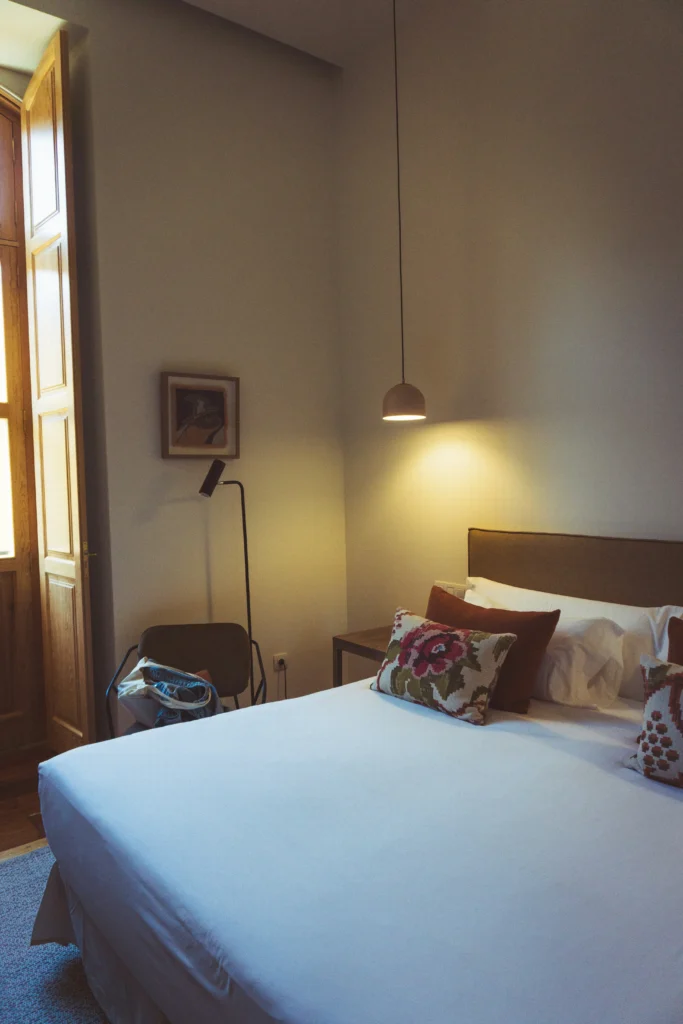 Rustic bedroom with dark wood French door and patterned pillows