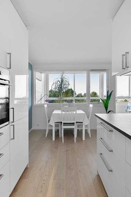 Scandinavian style kitchen with white cabinets and light wood floor