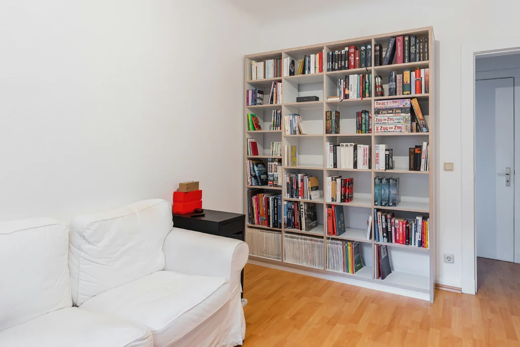 Minimalist living room with floor-to-ceiling bookshelf and white sofa