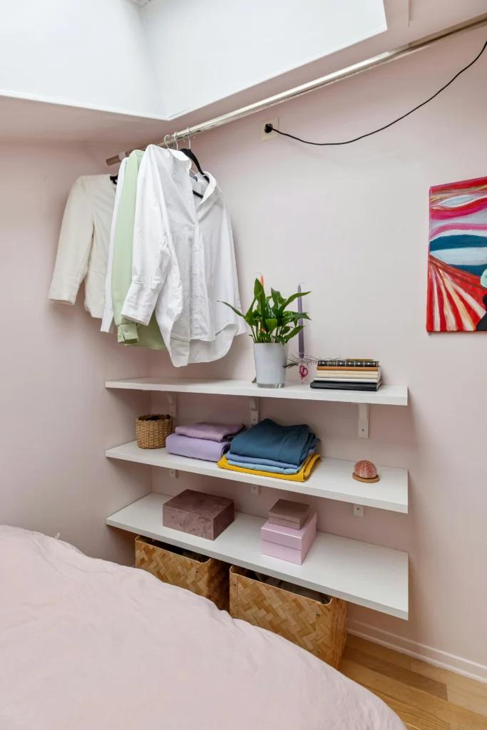 Wall shelves with books and decor in a small bedroom