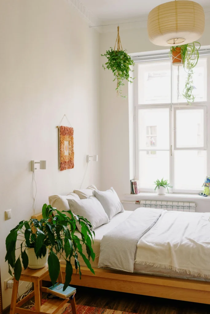 Small bedroom with hanging plants and woven decor