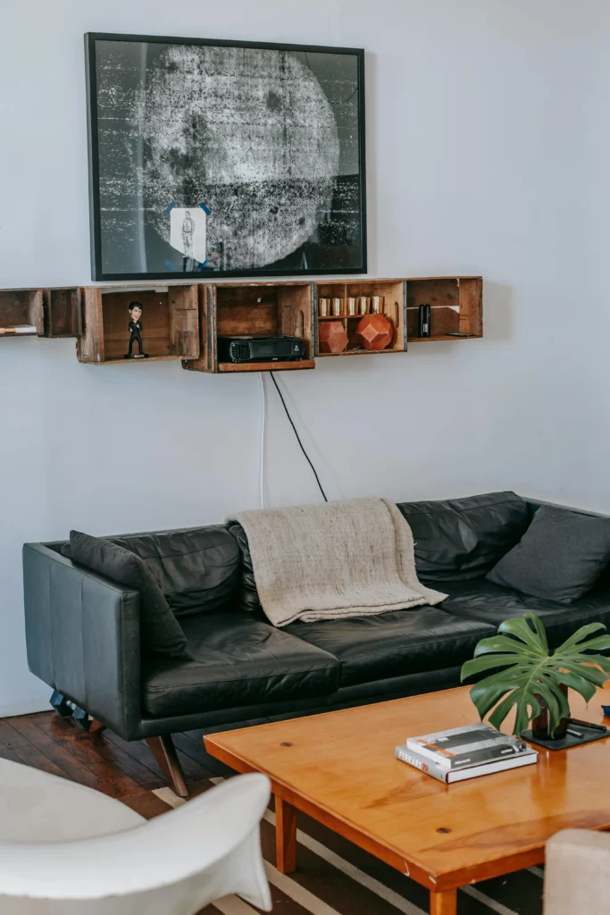 Industrial living room with black leather sofa and wooden crate shelves