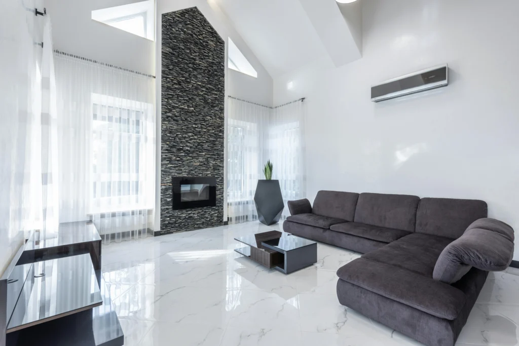 Living room with white marble floors and black sectional sofa