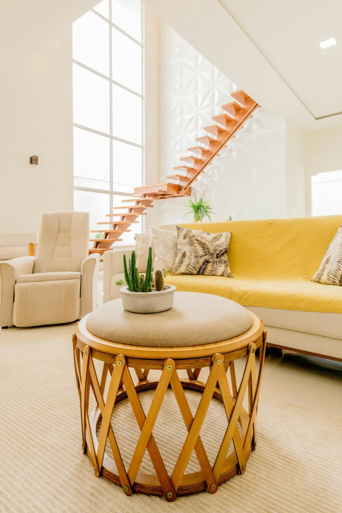 Bright living room with yellow sofa and floating staircase
