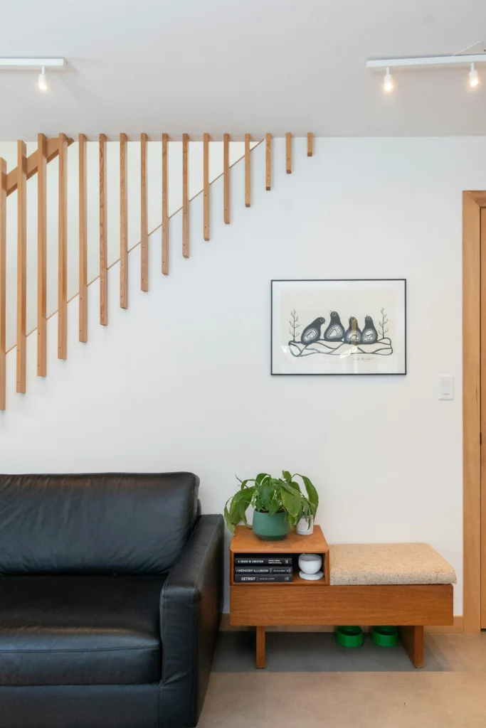 Living room with sculptural wooden staircase and built-in bench