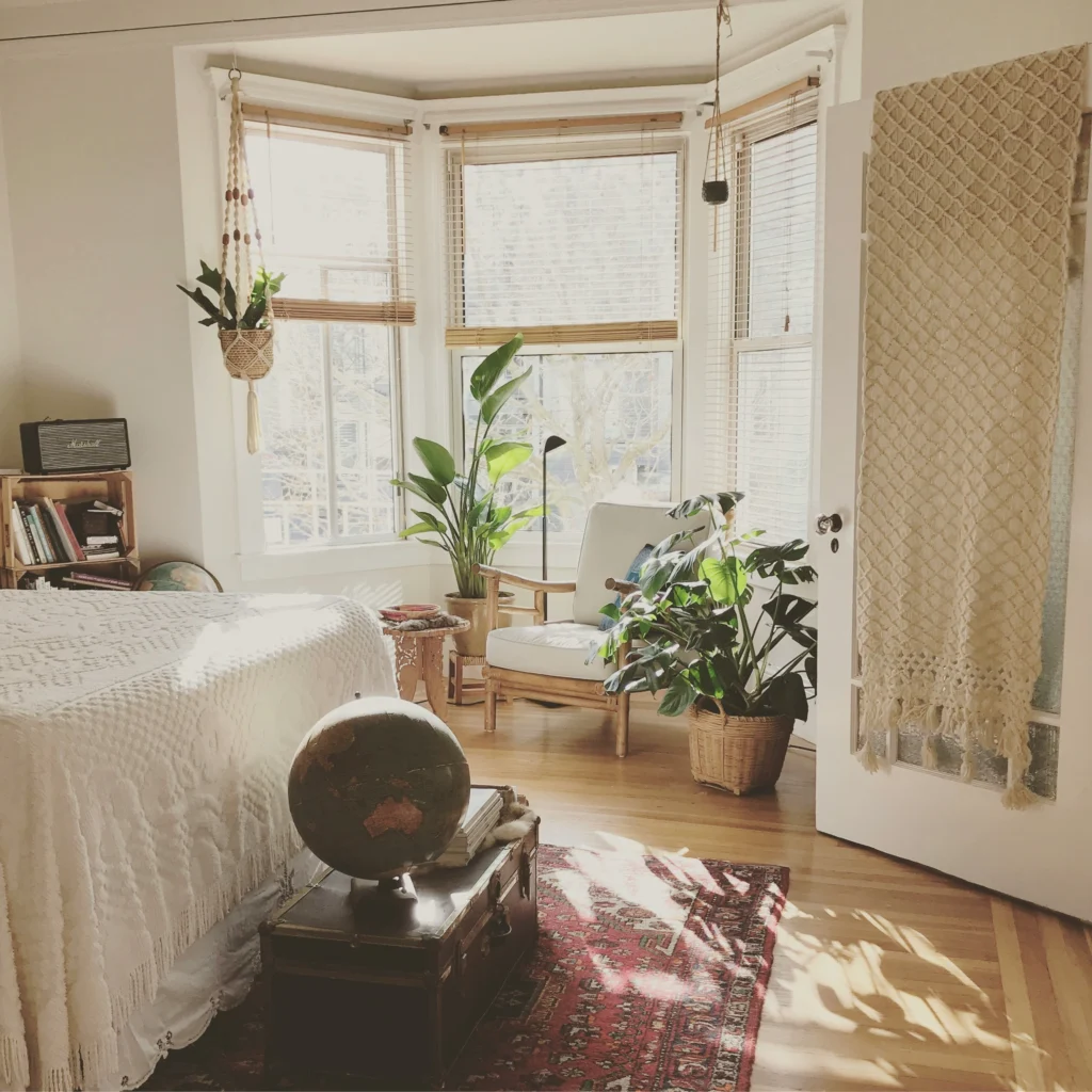 Sunlit boho bedroom with plants and bay windows