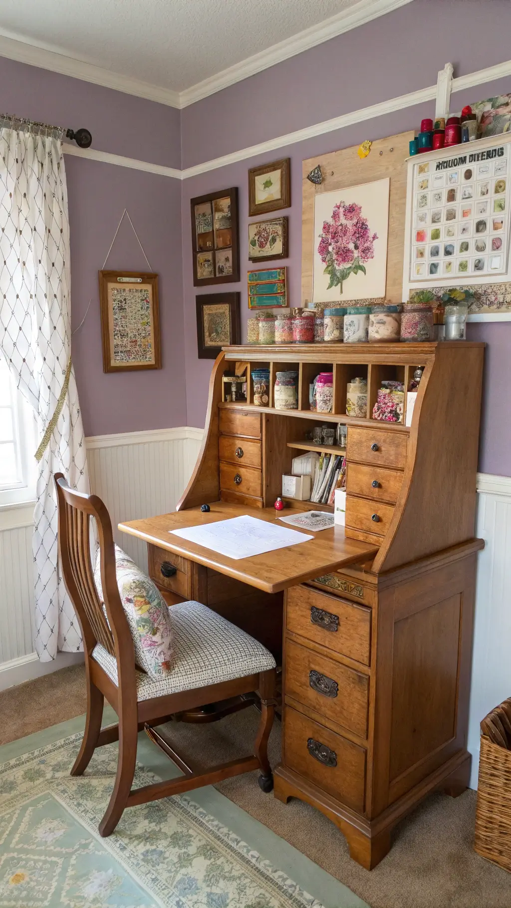 Antique secretary desk displaying vintage crafting supplies in a snug craft corner bathed in afternoon sunshine, complemented by a wooden chair with needlepoint roses on the cushion, cork board with fabric swatches and recipes, soft lavender walls, white trim, shelves of yarn, and glass jars.