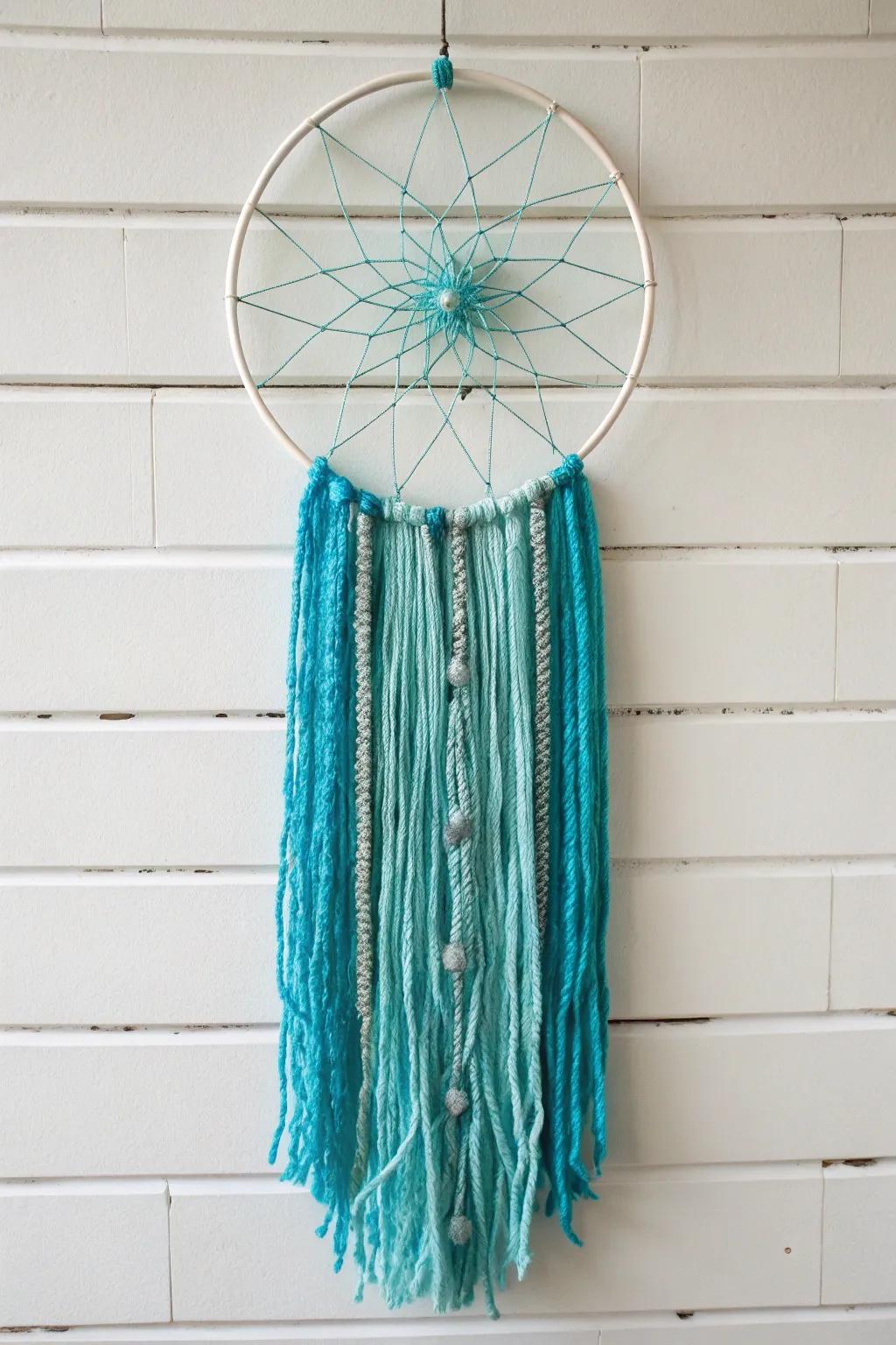 Turquoise bohemian dreamcatcher made with yarn and metal hoop.